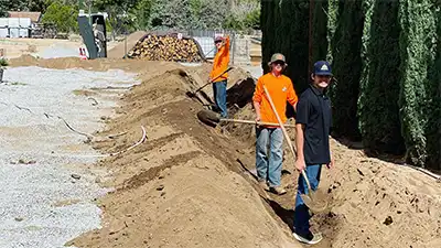 landscaping contractor digging a ditch